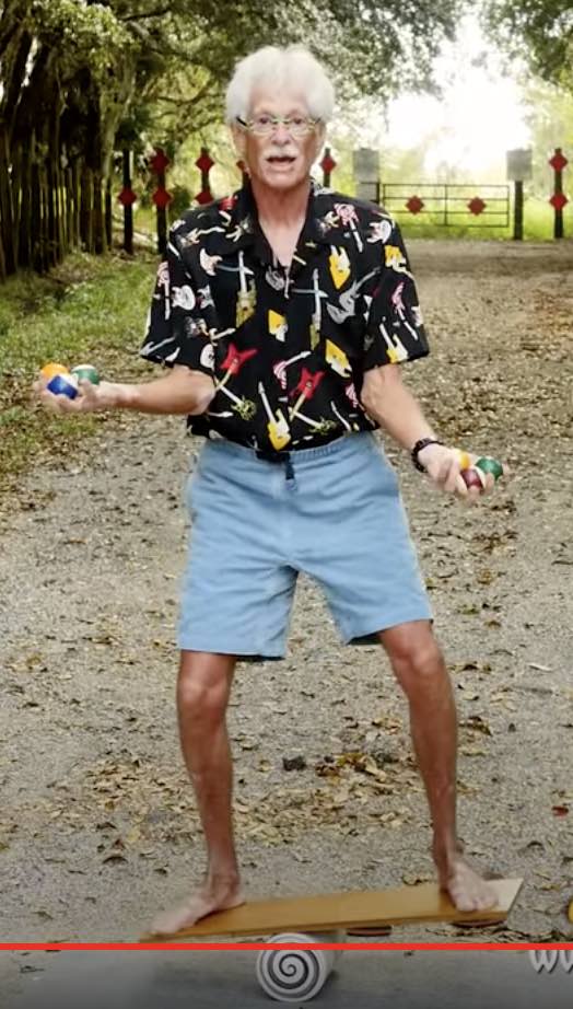 Stephen Jepson balancing with balls on a bongo board